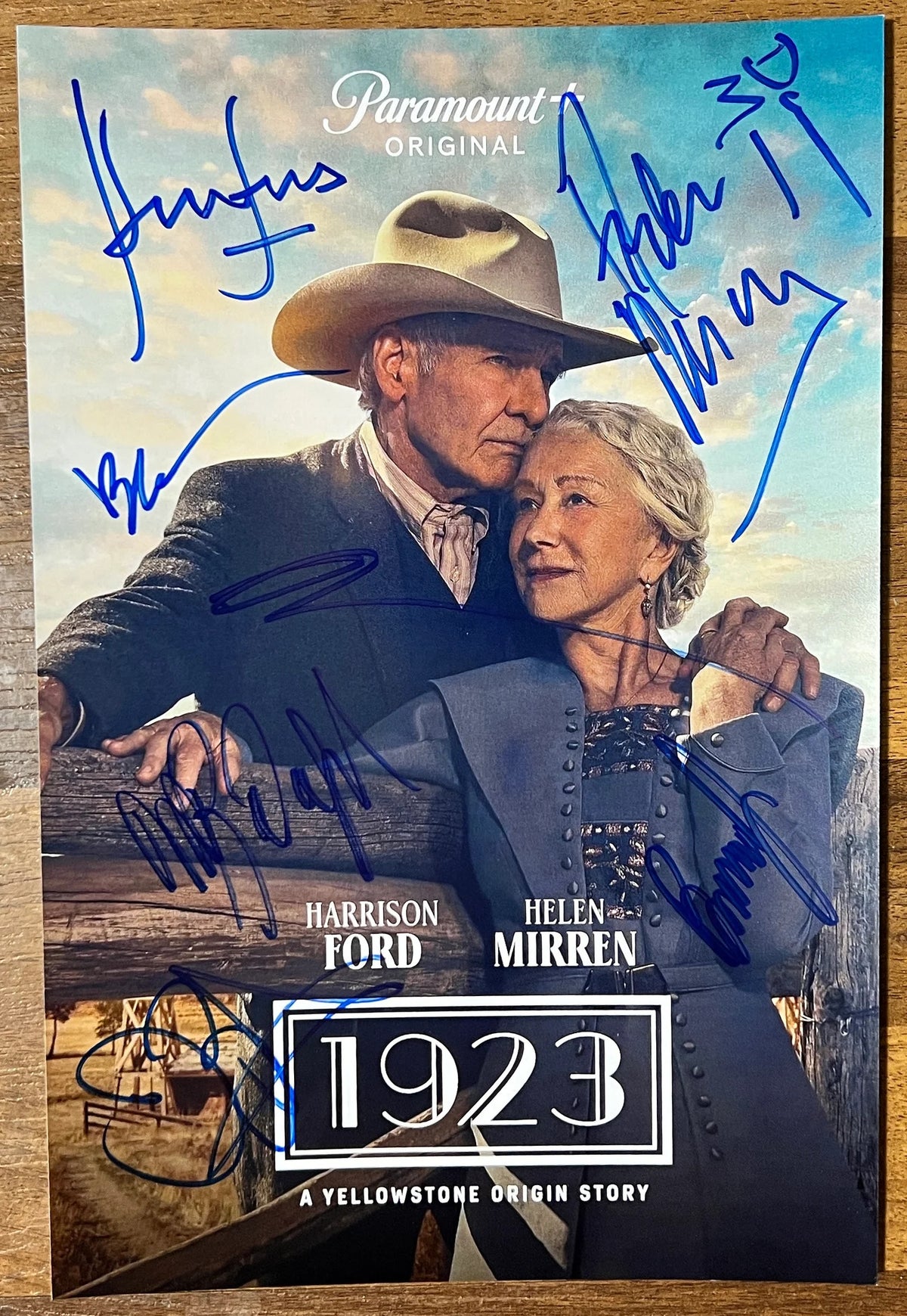 A cast autographed photo poster from the television series, 1923 A Yellowstone Origin Story. Signed photo of Harrison Ford, Helen Mirren, Brandon Sklenar, Darren Mann, Michelle Randolph, James Badge Dale, Marley Shelton and Brian Geraghty in blue ink markers signatures. Photograph Harrison Ford autographs for sale on 8x12 inch photo.