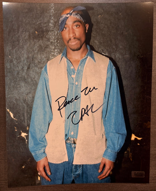 An autographed photo poster of rapper, 2pac Shakur, also known as Tupac Shakur. Signed photo in black ink marker signatures. Photograph 2pac autographs for sale on 8x10 inch picture.