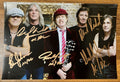 An autographed poster of the rock band ACDC. Signed photo of Brian Johnson, Angus Young, Malcolm Young, Phil Rudd and Cliff Williams in gold ink marker signatures. Photograph autographs for sale on 8x12 inch picture.