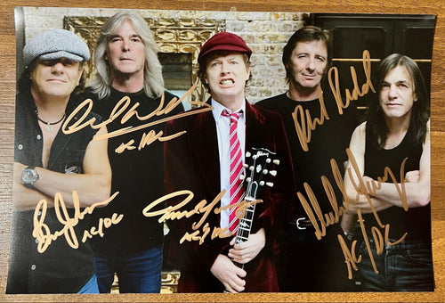 An autographed poster of the rock band ACDC. Signed photo of Brian Johnson, Angus Young, Malcolm Young, Phil Rudd and Cliff Williams in gold ink marker signatures. Photograph autographs for sale on 8x12 inch picture.
