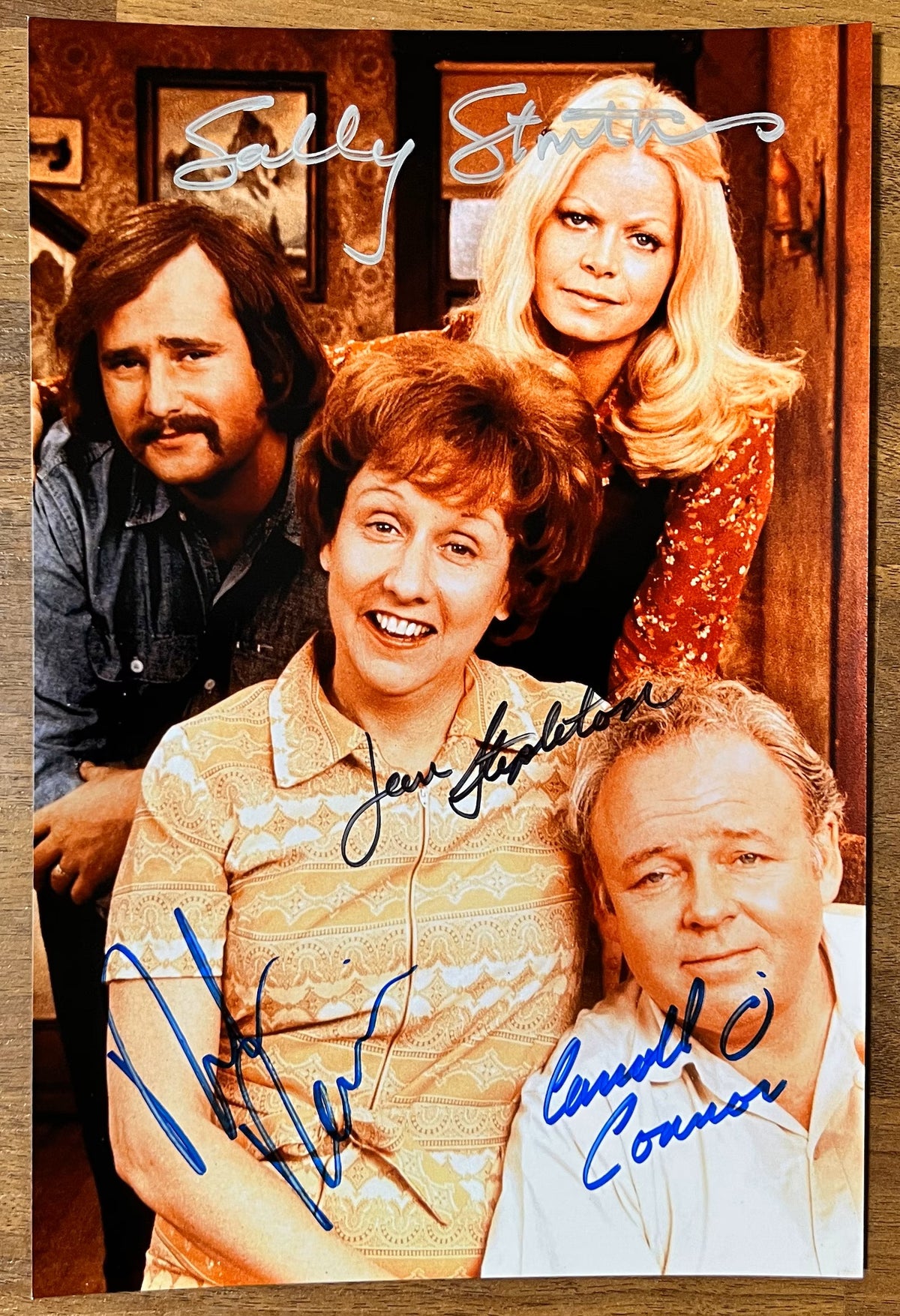 A cast autographed photo of the tv sitcom All in the Family. Signed poster by Carroll O'Connor, Jean Stapleton, Rob Reiner and Sally Struthers in silver black and blue ink markers signatures. Photograph autographs for sale on 8x12 inch picture.