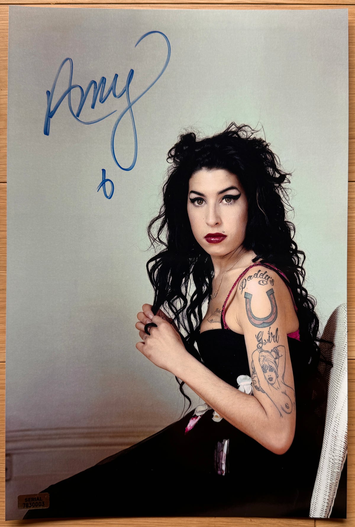 An autographed poster of rock and pop singer, Amy Winehouse. Signed photo in blue ink marker signatures. Photograph autographs for sale on 8x12 inch picture.