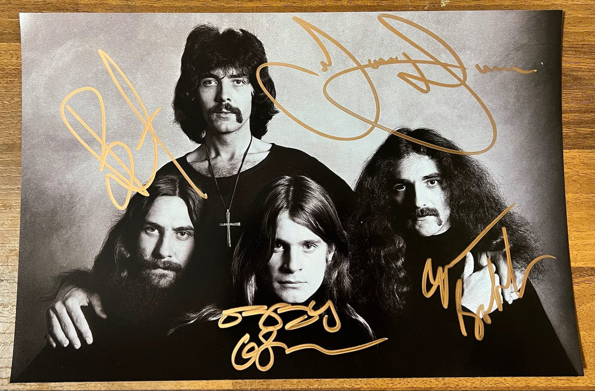 An autographed poster of the heavy metal band, Black Sabbath. Signed photo of Ozzy Osbourne, Tony Iommi, Bill Ward and Geezer Butler in gold marker ink signatures. Photograph autographs for sale on 8x12 inch picture.