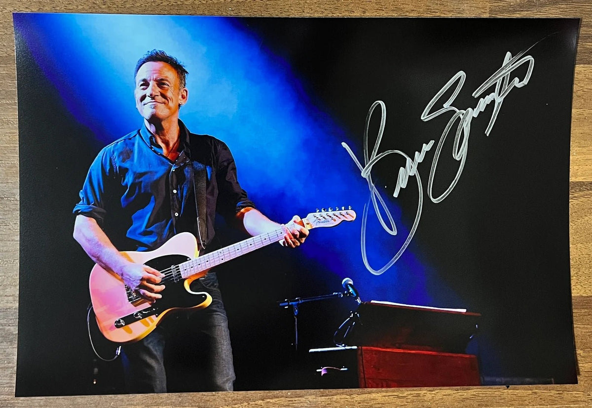 A poster signed by musician, Bruce Springsteen. Signed photo in silver ink marker signatures. Photograph autographs for sale on 8x12 inch picture.