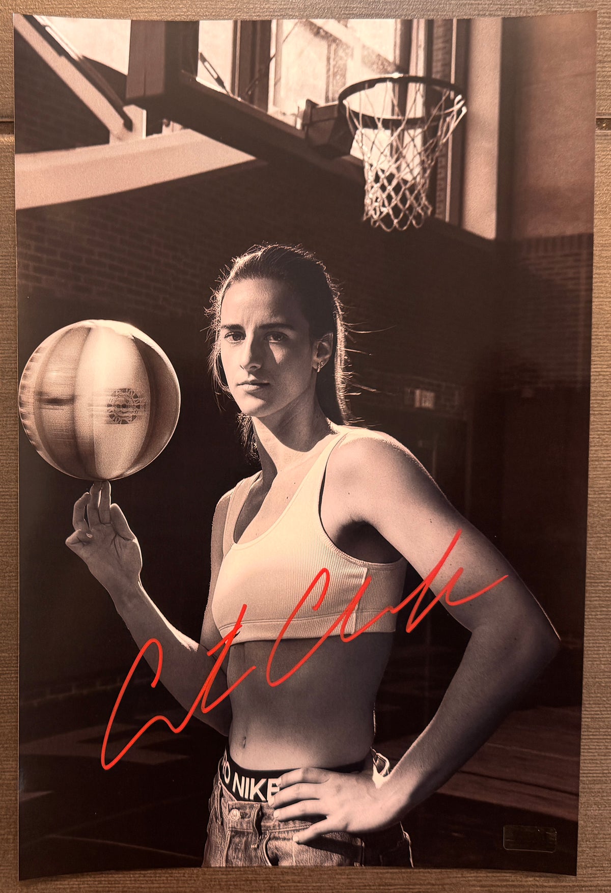 An autographed panini prizm rookie patch photo poster of WNBA Indiana Fever player, Caitlin Clark. Signed photograph in red paint pen ink marker signatures. Photograph Caitlin Clark autographs for sale on 8x12 inch picture.