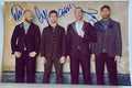 autographed photo of the band Coldplay. autograph signed by Chris Martin, Jonny Buckland, Guy Berryman and Will Champion in blue ink on 8x12 inch photograph poster coldplay autographs for sale.