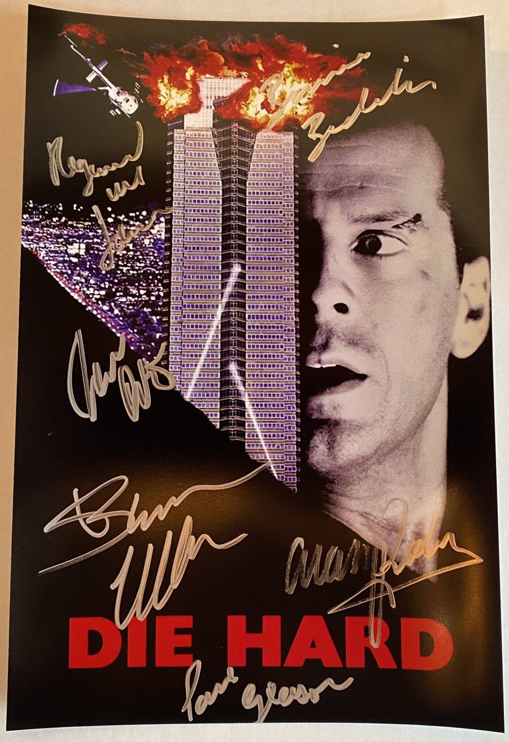 A cast autographed photo poster from the movie, Die Hard. Signed photo of Bruce Willis, Alan Rickman, Bonnie Bedelia, Reginald VelJohnson, Paul Gleason and William Atherton in silver ink marker signatures. Photograph Bruce Willis autographs for sale on 8x12 inch picture.