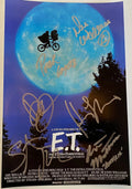 A cast autographed photo poster of the movie E.T. Signed photo of Henry Thomas, Drew Barrymore, Dee Wallace, Michael MacNaughton, Peter Coyote and Steven Spielberg in silver ink marker signatures. Photograph autographs for sale on 8x12 inch picture.