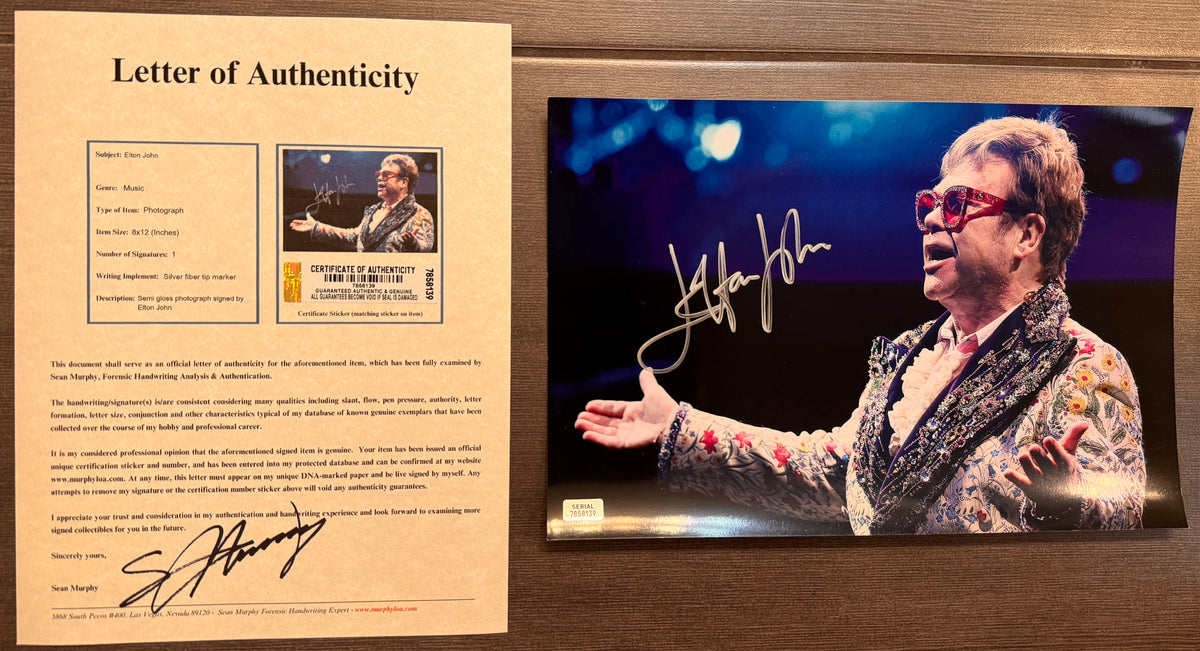An autographed photo poster of the pop rock star musician, Elton John. Signed photograph in silver ink marker signatures. Photograph Elton John autographs for sale on 8x12 inch picture with COA.