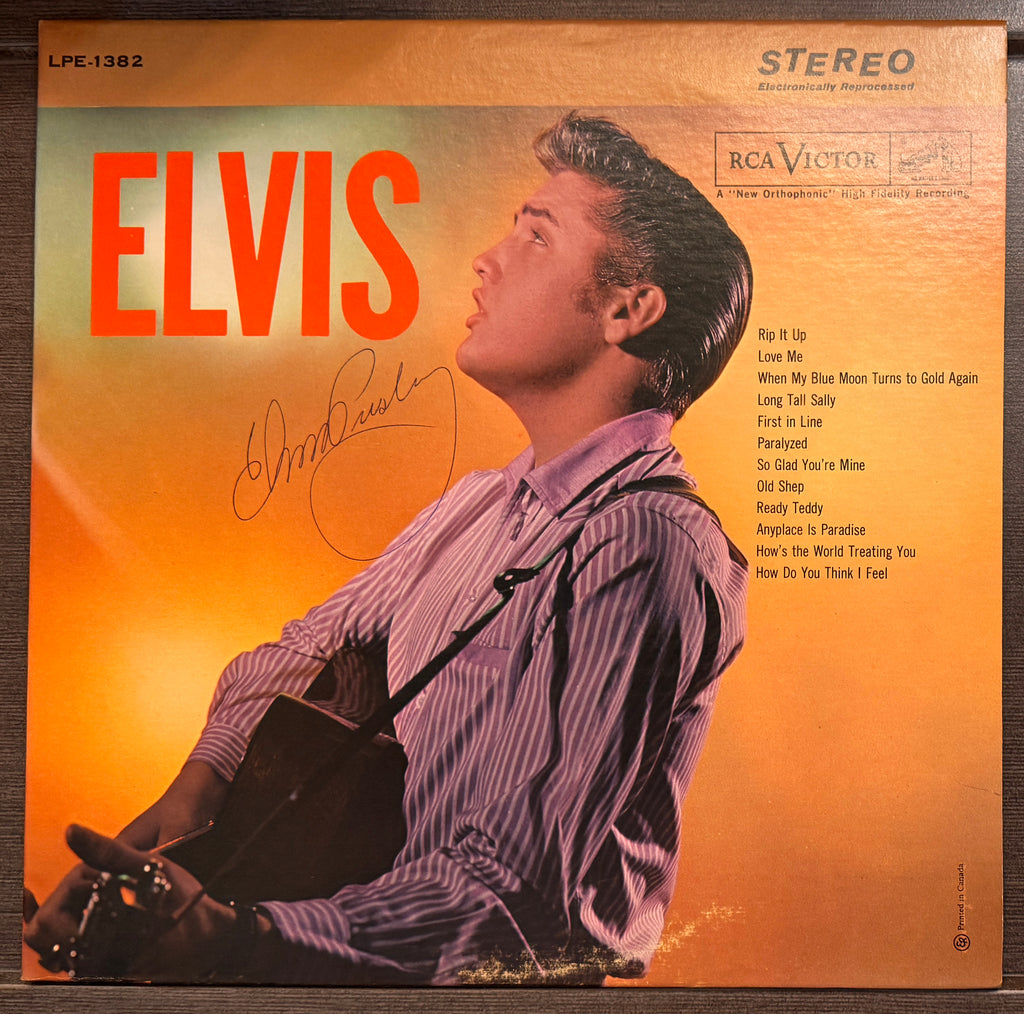 an autographed self-titled record album LP of Elvis Presley. signed in blue ink on the front cover. autograph in mint condition with certificate of authenticity. 
