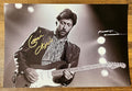 A signed black and white photograph of rock singer, Eric Clapton. autographed  photo poster in gold ink marker signatures. photograph Eric Clapton autographs for sale on 8x12 inch picture.