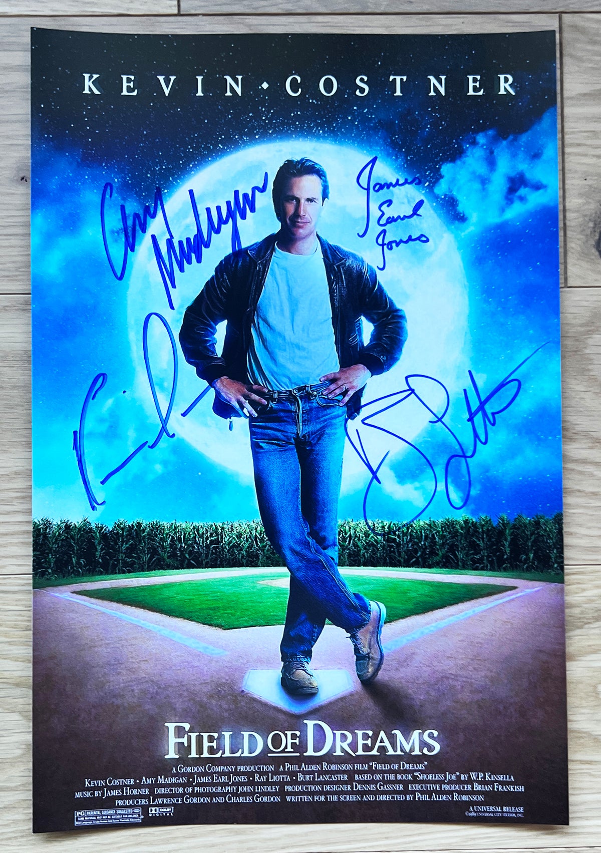 A cast autographed poster of the movie Field of Dreams. Signed photo of Kevin Costner, Ray Liotta, James Earl Jones and Amy Madigan in blue ink marker signatures. Photograph autographs for sale on 8x12 inch picture.
