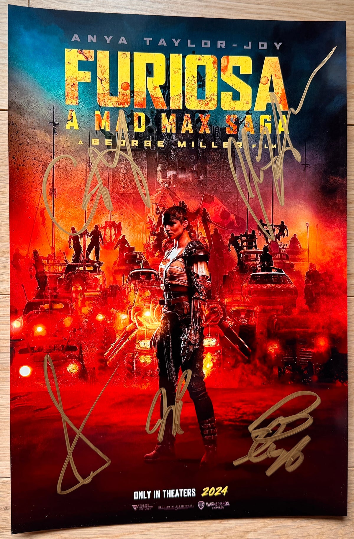 A cast autographed photo poster from the movie, Furiosa A Mad Max Saga. Signed photo of Anya-Taylor-Joy, Chris Hemsworth, Tom Burke, Alyla Browne and George Miller in gold ink marker signatures. Photograph Furiso Mad Max Sage autographs for sale on picture.