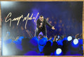 An autographed poster of musician pop star, George Michael. Signed photo in gold ink marker signatures. Photograph autographs for sale on 8x12 inch picture.