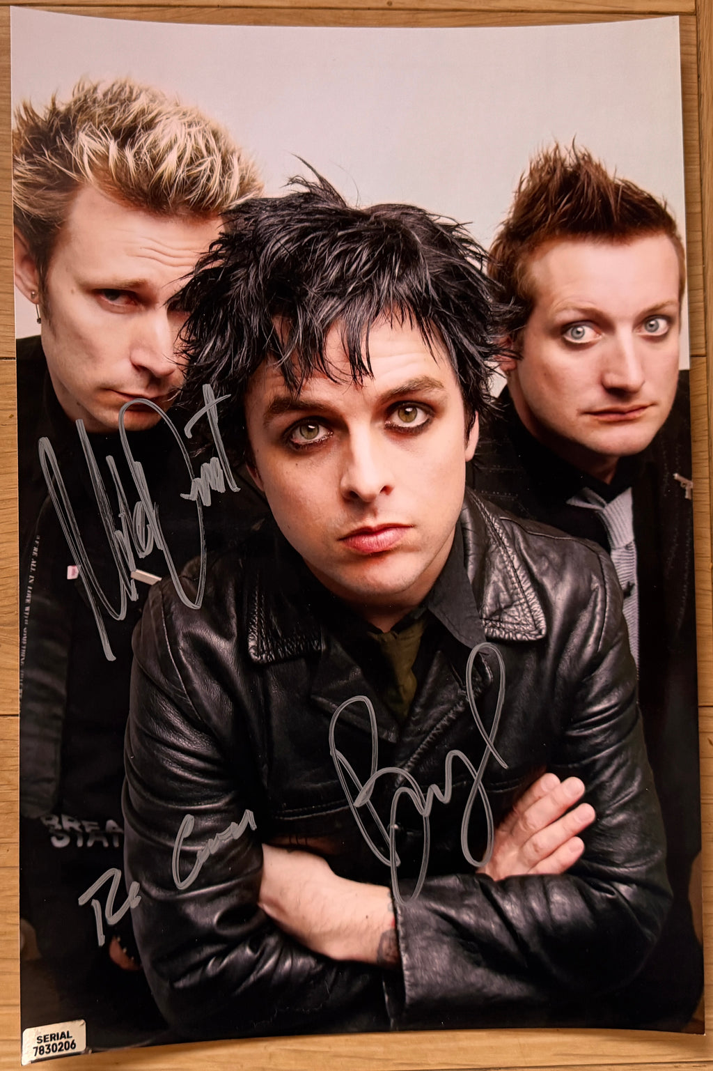 An autographed photo poster of the rock band, Green Day. Signed photo of Billie Joe Armstrong, Mike Dirnt and Tre Cool in silver ink marker signatures. Photograph autographs for sale on 8x12 inch picture.