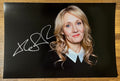 An autographed poster of Harry Potter author, J.K. Rowling. Signed photo in silver ink marker signature. Photograph autographs for sale on 8x12 inch picture.