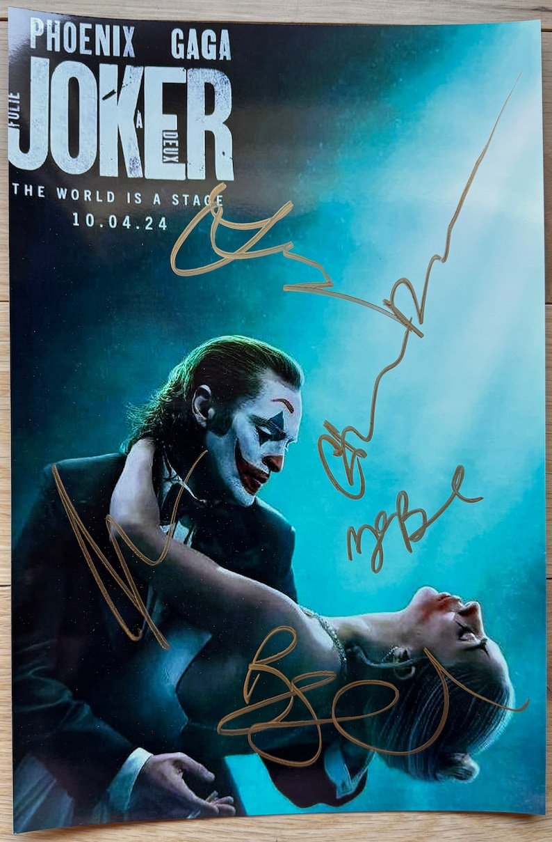A cast autographed photo of the movie, Joker Folie a Deux. Signed poster of Joaquin Phoenix, Lady gaga, Zazie Beetz, Catherin Keener and Brendan Gleeson in gold ink marker signatures. Photograph autographs for sale on 8x12 inch picture.