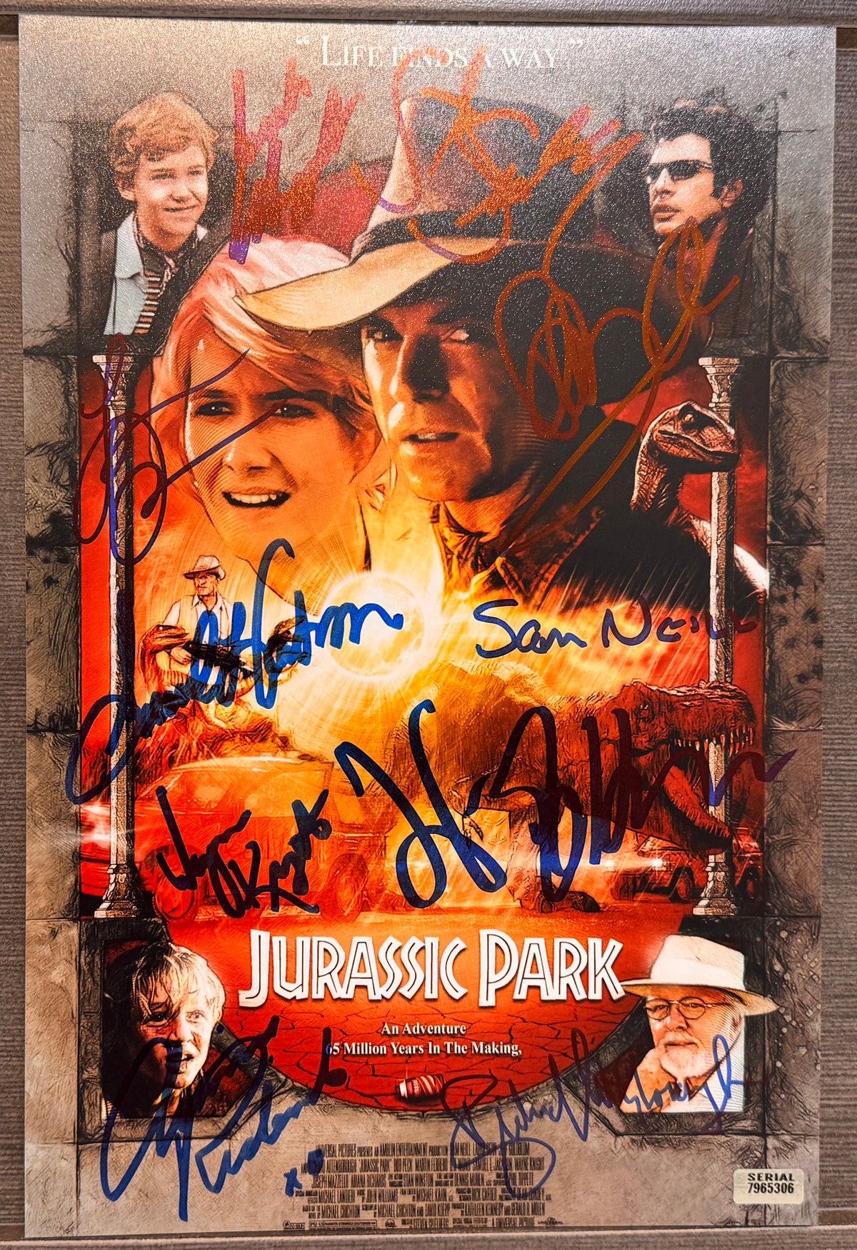 A cast autographed 8x12 Jurassic Park movie poster. Signed photo of Sam Neill, Laura Dern, Jeff Goldblum, Richard Attenborough, Joseph Mazzello, Ariana Richards, Samuel L. Jackson, Wayne Knight, Steven Spielberg and BD Wong in blue ink marker signatures. Photograph autographs for sale on 8x12 inch picture.