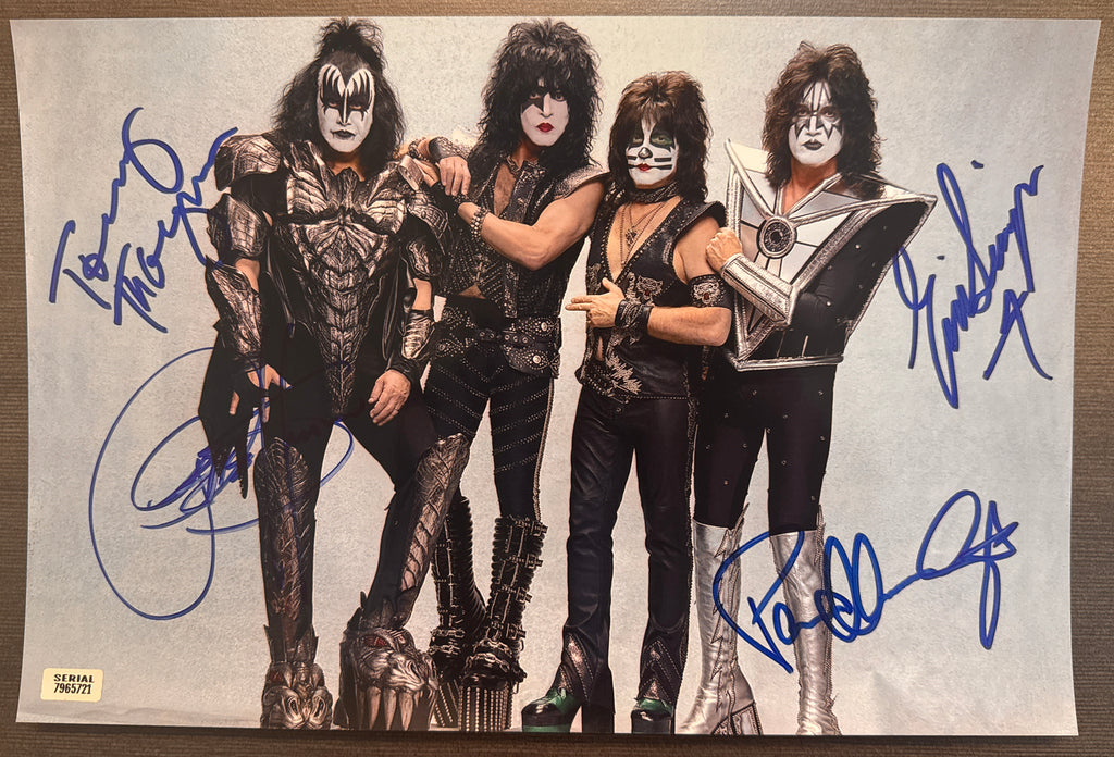 A complete autographed photo poster of the rock n roll band, KISS. Signed photo of Gene Simmons, Paul Stanley, Eric Singer and Tommy Thayer in blue ink marker signatures. Photograph KISS autographs for sale on 8x12 inch picture.