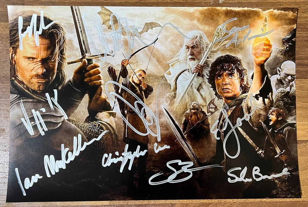 A cast autographed poster of the movie series, The Lord of the Rings. Signed photo of Elijah Wood, Sean Astin, Ian McKellen, Christopher Lee, Sean Bean, Liv Tyler, Viggo Mortensen, Orlando Bloom, Cate Blanchett and Sala Baker in silver ink marker signatures. Photograph autographs for sale on 8x12 inch picture.