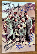 A cast autographed poster of the television series, MASH also known as M*A*S*H*. Signed photo of Alan Alda, Jamie Farr, Loretta Swit, William Christopher, Harry Morgan, Mike Farrell and David Ogden Stiers in blue and black ink marker signatures. Photograph autographs for sale on 8x12 inch picture.