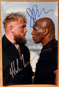 An autographed photo poster print of a face-off between Mike Tyson and Jake Paul before their boxing fight, signed photograph in blue and silver ink, poster 8x12 inches in size. Jake Paul Mike Tyson utographs for sale on picture.