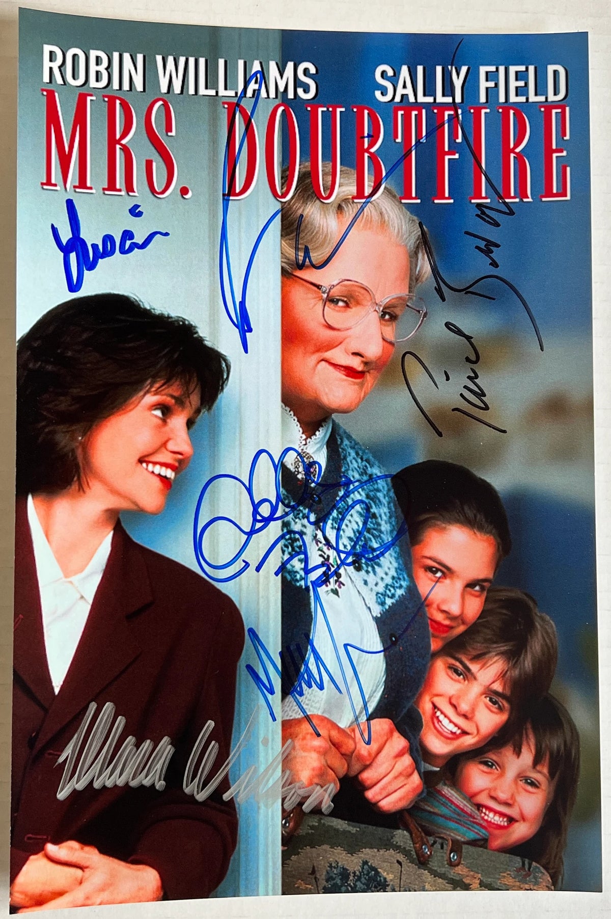 A cast autographed poster of the movie Mrs. Doubtfire. Signed photo of Robin Williams, Sally Field, Pierce Brosnan, Lisa Jakub, Matthew Lawrence and Mara Wilson in blue black and silver ink signatures. Photograph autographs for sale on 8x12 inch picture.