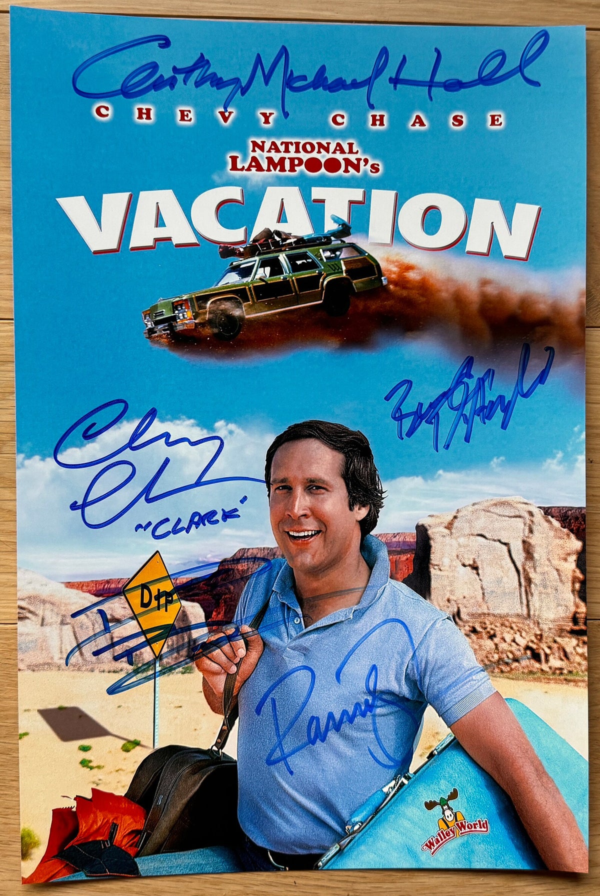 A cast autographed photo poster from the movie,  National Lampoon's Vacation. Signed photo of Chevy Chase, Beverly D'Angelo, Randy Quaid, Anthony Michael Hall and Dana Barron in blue ink markers signatures. Photograph Chevy Chase autographs for sale on 8x12 inch picture.