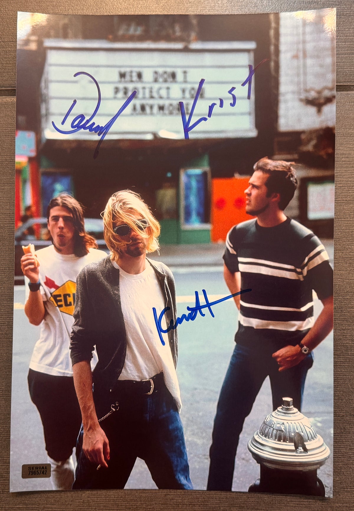 An autographed photo poster of the 90's band, Nirvana. Signed photo of Kurt Cobain Dave Grohl and Krist Novoselic in blue ink marker signatures. Photograph Kurt Cobain autographs for sale on an 8x12 inch picture.