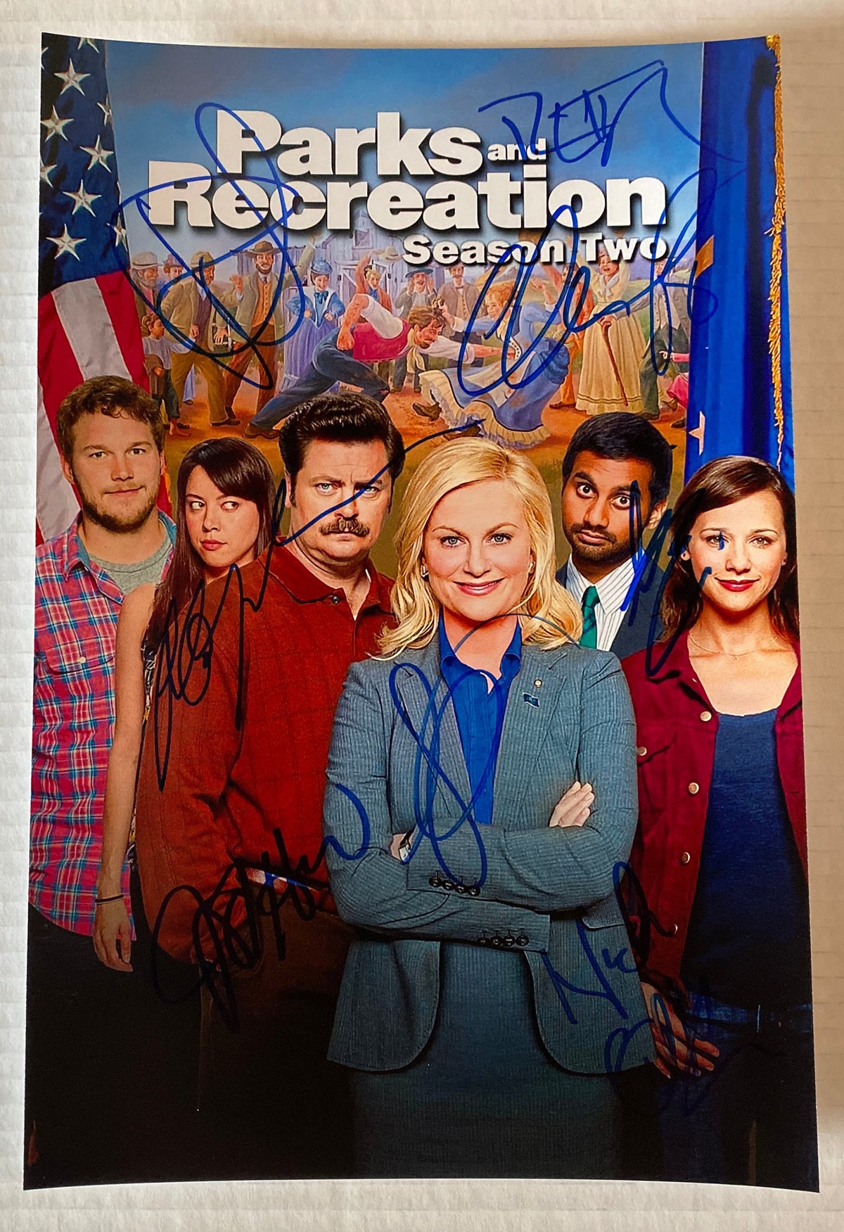 A cast autographed Parks and Recreation Season 2 photo. Signed photo of Amy Poehler, Nick Offerman, Aubrey Plaza, Chris Pratt, Aziz Ansari, Jim O'Heir, Retta and Rashida Jones in blue ink marker signatures. Photograph autographs for sale on 8x12 inch picture.