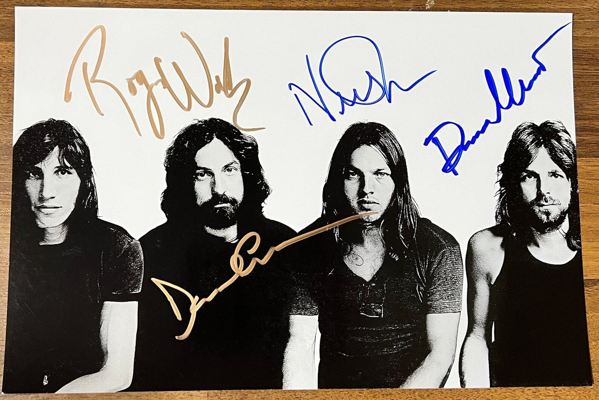 An autographed poster of the band Pink Floyd. Signed poster by Roger Waters, David Gilmour, Richard Wright and Nick Mason in blue and gold ink marker signatures. Photograph autographs for sale on 8x12 inch picture.