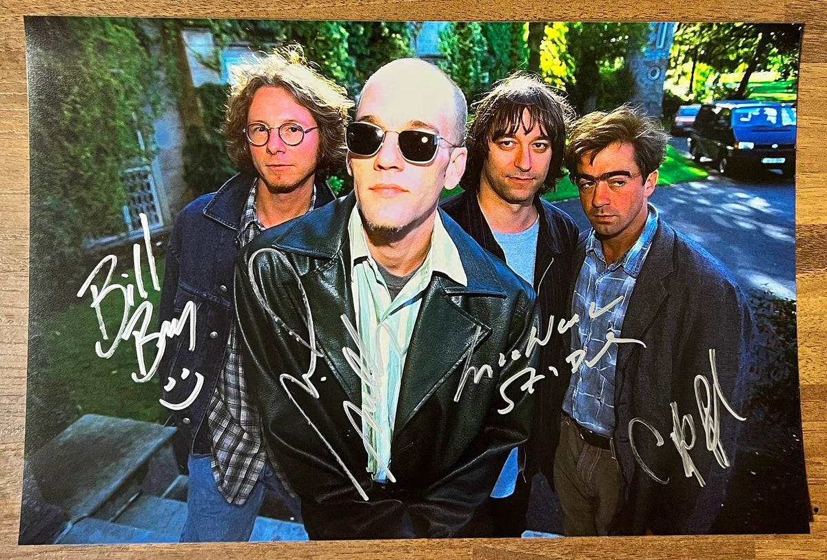 An autographed poster of the rock band, R.E.M. also known as REM. Signed photo of Michael Stipe, Mike Mills, Peter Buck and Bill Berry in silver ink marker signatures. Photograph autographs for sale on 8x12 inch picture.