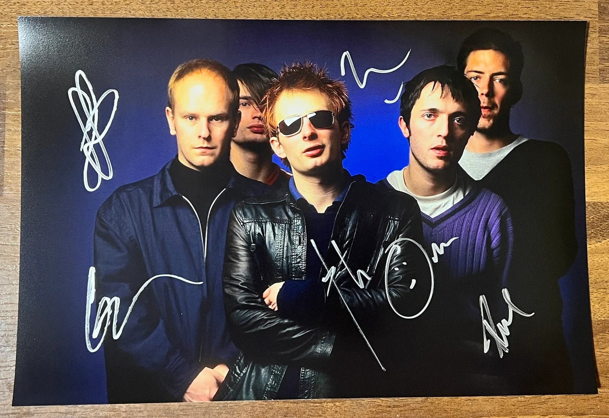 an autographed photo of the band Radiohead. signed poster by Thom Yorke, Jonny Greenwood, Colin Greenwood, Ed O'Brien and Philip Selway in silver ink signatures on the front. photograph autographs for sale. 8x12 inch picture.
