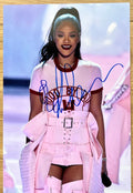 An autographed photo poster of hip hop pop singer, Rihanna. Signed photo in blue ink marker signatures. Photograph Rihanna autographs for sale on 8x12 inch picture.