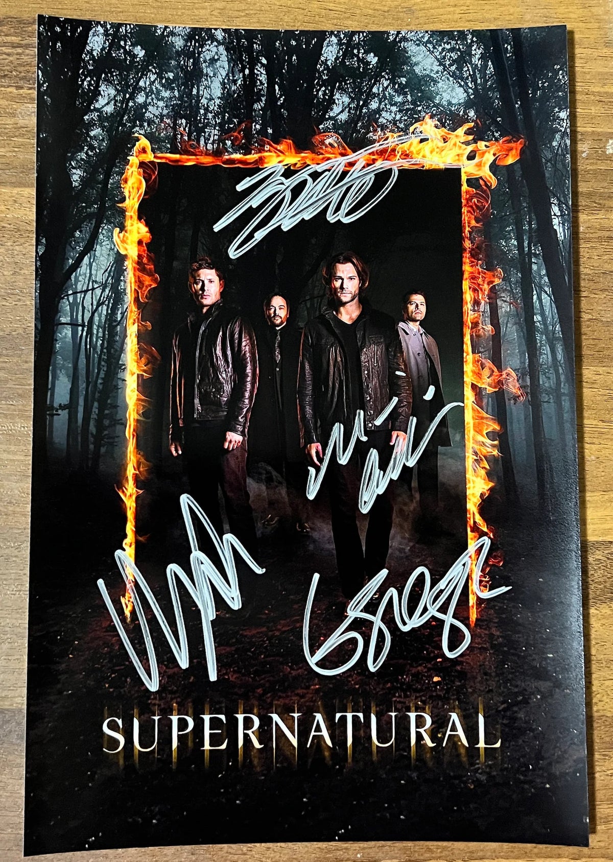 A cast autographed poster of the television series, Supernatural. Signed photo of Jared Padalecki, Jensen Ackles, Misha Collins and Mark Sheppard in silver ink marker signatures. Photograph autographs for sale on 8x12 inch picture.