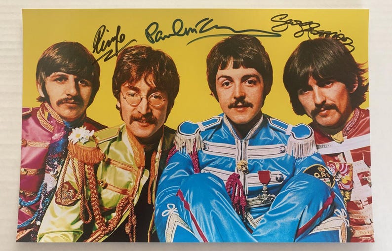 A band autographed poster of The Beatles. Signed photo of Paul McCartney, George Harrison and Ringo Starr in blue ink markers signatures. Photograph autographs for sale on 8x12 inch picture.