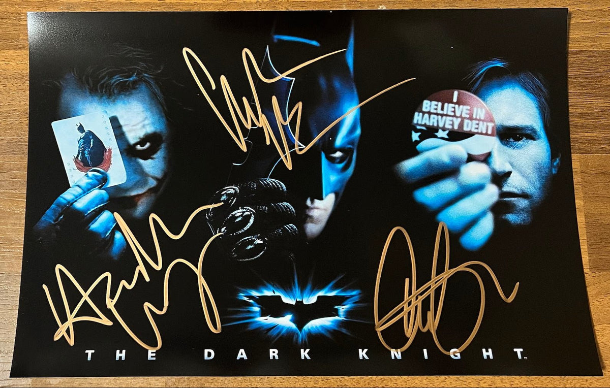 A cast autographed poster from the movie, The Dark Knight from the superhero Batman universe. Signed photo of Heath Ledger, Christian Bale and Aaron Eckhart in gold ink marker signatures. Photograph autographs for sale on 8x12 inch picture.