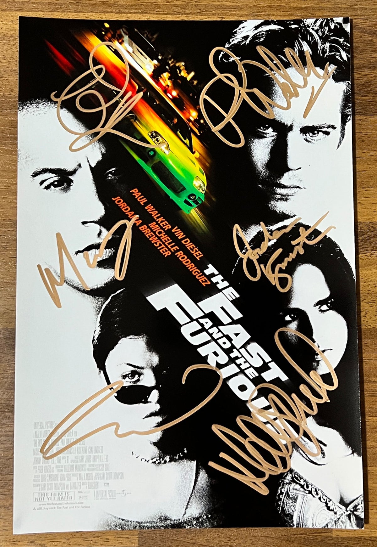 A cast autographed 8x12 movie poster for 'The Fast and the Furious'. Signed photo of Paul Walker, Vin Diesel, Michelle Rodriguez, Jordana Brewster, Chad Lindberg and Matt Schulze in gold ink markers signatures. Photograph autographs for sale on 8x12 inch picture.