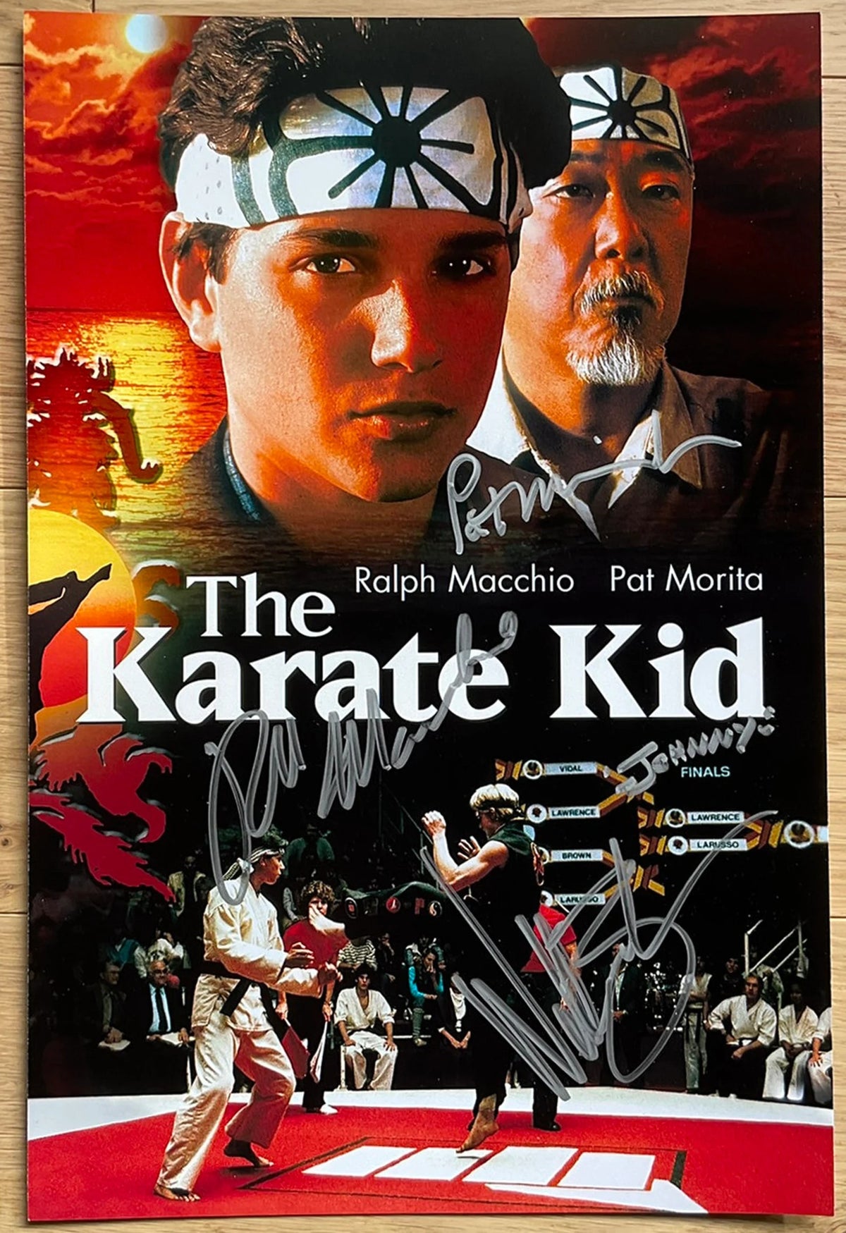 A cast autographed photo poster from the movie, The Karate Kid. Signed photo of Pat Morita, Ralph Macchio and William Zabka in silver ink marker signatures. Photograph Karate Kid autographs for sale on 8x12 inch picture.