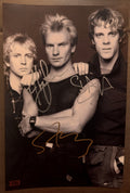 An autographed photo poster of the rock band, The Police. Signed photograph of Sting, Stewart Copeland and Andy Summers in silver and gold ink marker signatures. Photograph The Police autographs for sale on 8x12 inch picture.