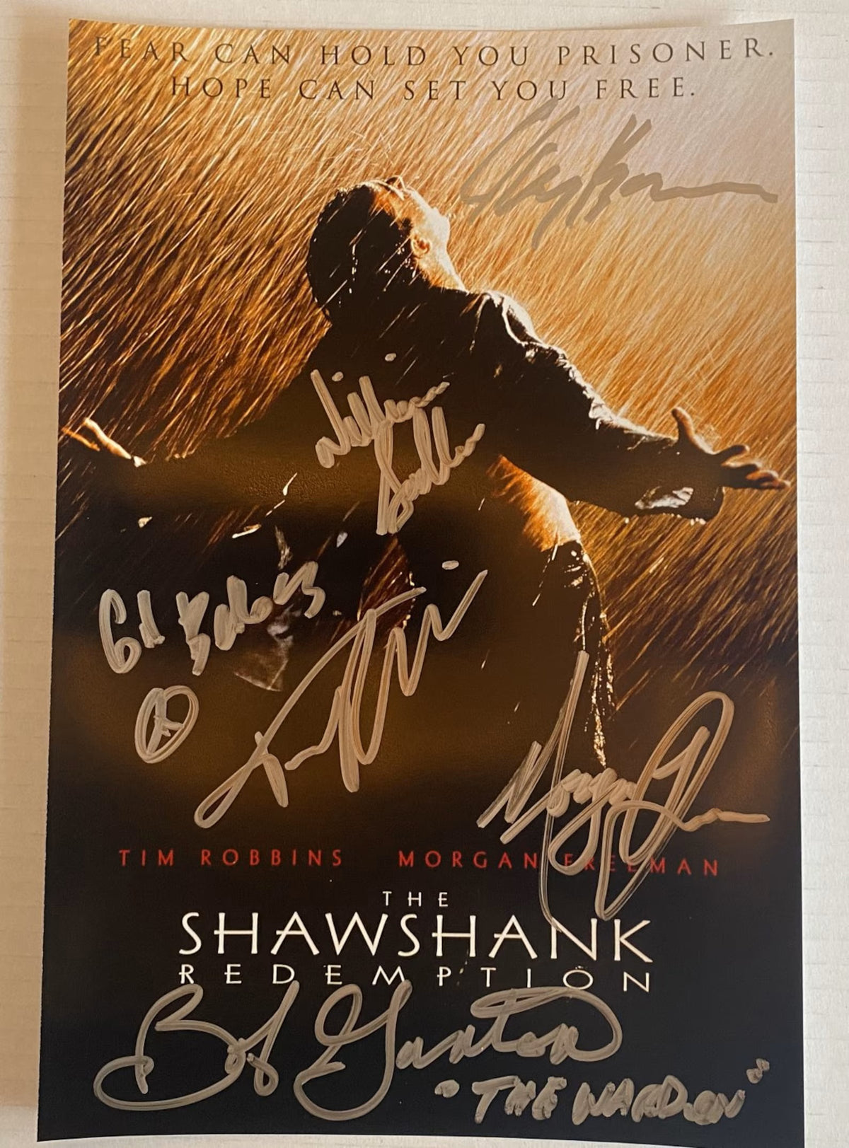 A cast autographed movie photo poster for 'The Shawshank Redemption', Signed photograph of Morgan Freeman, Tim Robbins, Bob Gunton, Gil Bellows, William Sadler and Clancy Brown in silver ink markers signatures. Photograph autographs for sale on 8x12 inch picture . 