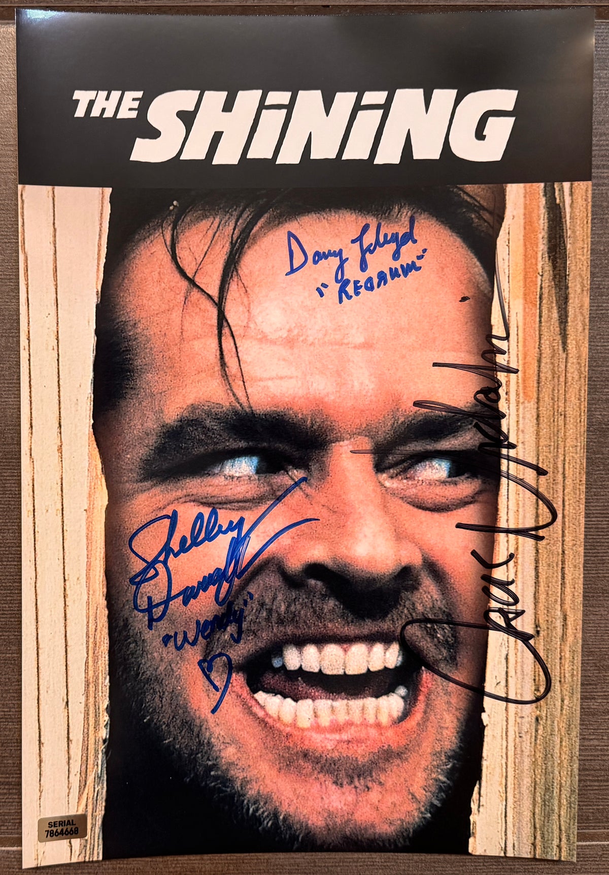 A cast autographed photo poster from the movie, The Shining. Signed photo of Jack Nicholson, Shelley Duvall and Danny Lloyd in blue markers signatures. Photograph Jack Nicholson autographs for sale on 8x12 inch picture.