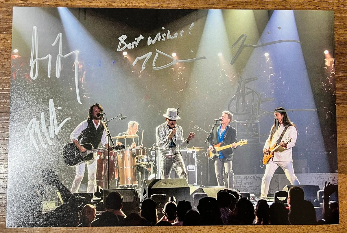 an autographed photo of the band The Tragically Hip. Signed photo by band members Gord Downie, Johnny Fay, Rob Baker, Gord Sinclair and Paul Langlois in silver ink signatures on the photograph. poster is 8x12 inches in size. Gord Downie autographs for sale.
