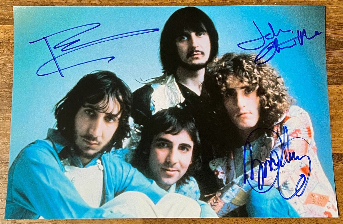 An autographed photo poster of the rock band The Who. Signed poster of Roger Daltrey, Pete Townshend and John Entwistle in blue ink markers signatures. Photograph The Who autographs for sale on 8x12 inch picture.