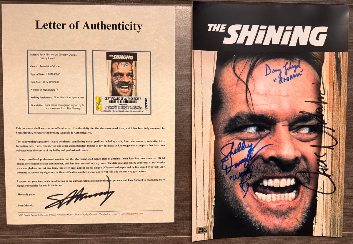 An autographed 'The Shining' movie poster. Signed photo of Jack Nicholson, Shelley Duvall and Danny Lloyd in blue markers. Photograph autographs for sale on 8x12 inch picture with COA.