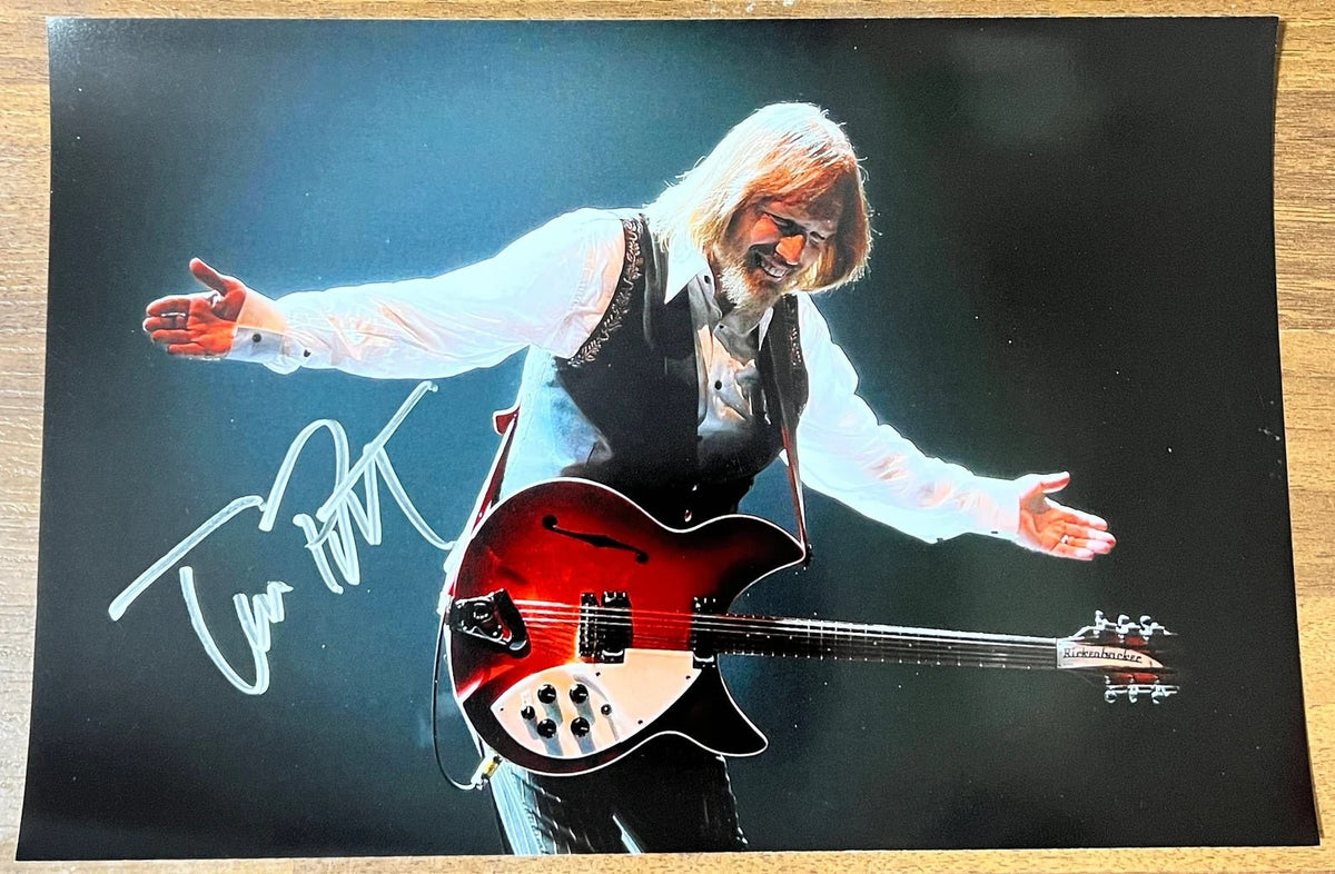 photograph poster signed by Tom Petty and the Heartbreakers. autographed in silver ink on an 8x12 inch photo. autographs for sale on collectible picture.
