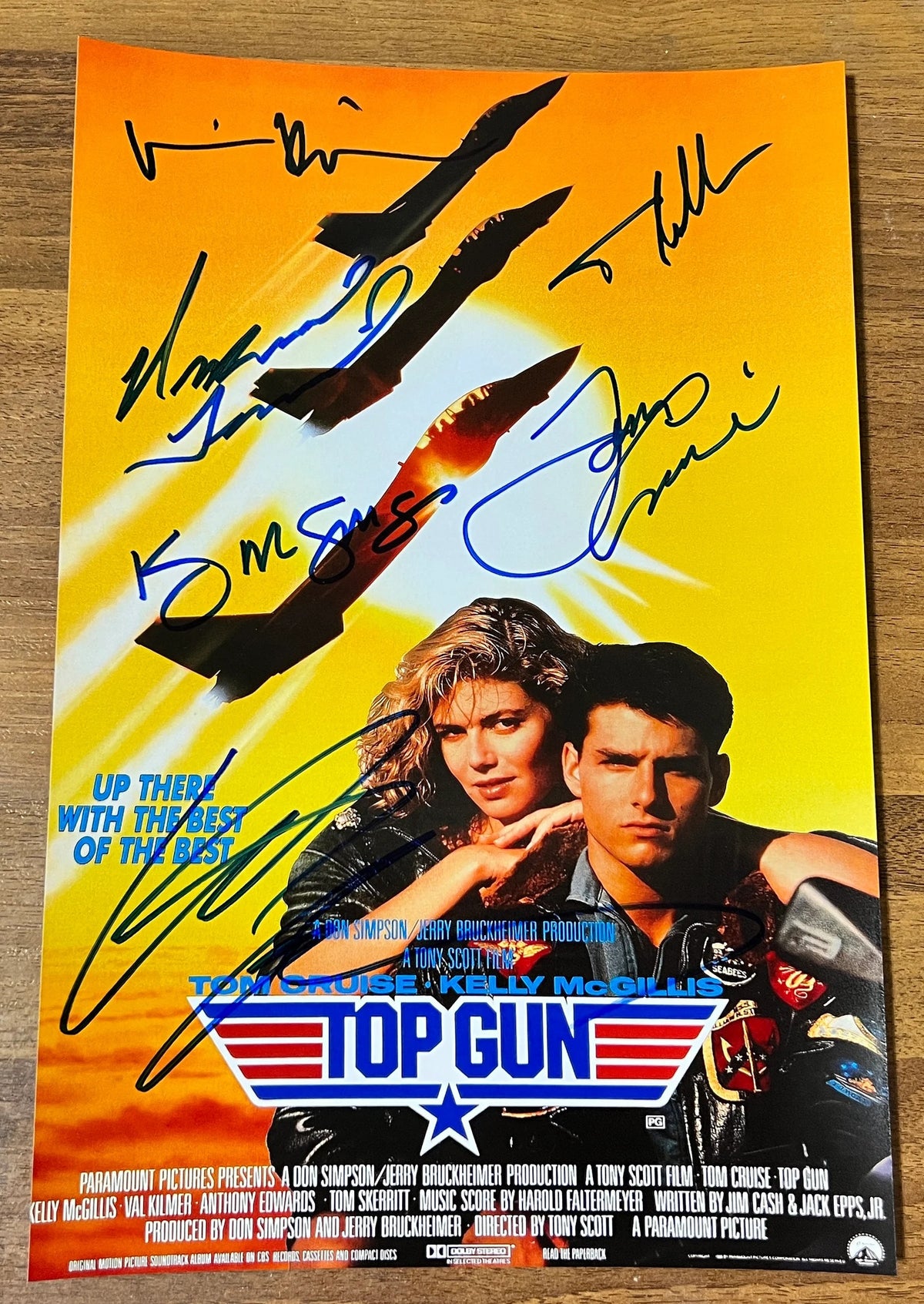 A cast autographed 'Top Gun' movie poster. Signed photo of Tom Cruise, Kelly McGillis, Val Kilmer, Tim Robbins, Michael Ironside and Anthony Edwards in blue ink markers. Photograph autographs for sale on 8x12 inch picture.