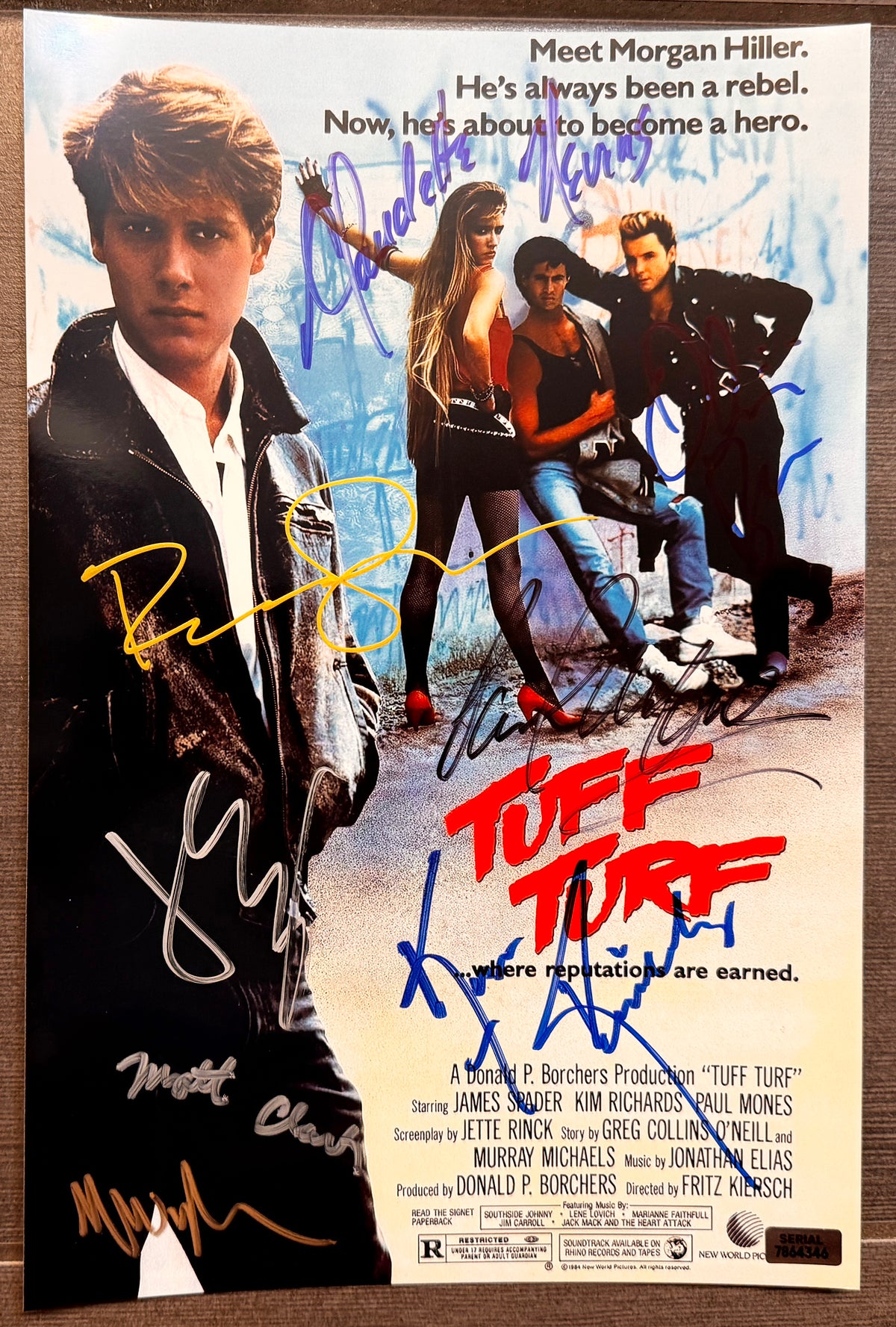 A cast autographed photo poster from the movie, Tuff Turf. Signed photo by James Spader, Kim Richards, Paul Mones, Robert Downey Jr, Matt Clark, Claudette Nevins, Olivia Barash, Michael Wyle in blue black gold silver ink markers signatures. photograph Tuff Turf autographs for sale on 8x12 inch picture.