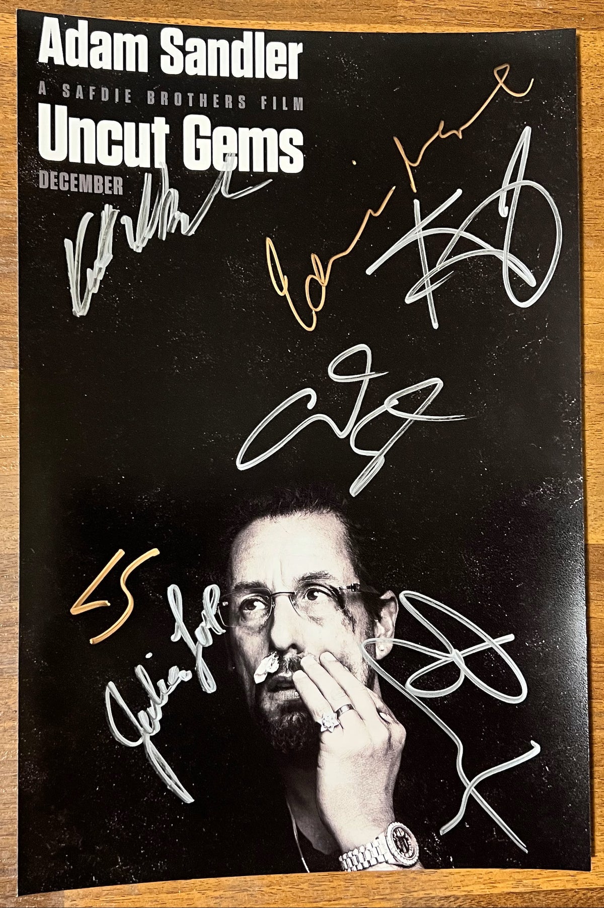 A cast autographed photo poster from the movie, Uncut Gems. Signed photo of Adam Sandler, Kevin Garnett, LaKeith Stanfield, Julia Fox, Idina Menzel, Eric Bogosian and Keith Williams Richards in silver and gold ink marker signatures. Photograph autographs for sale on 8x12 inch picture.