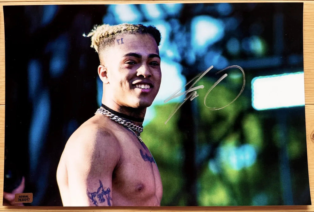 An autographed photo poster of hip hop rapper, XXXTentacion. Signed photo in silver ink marker signatures. Photograph xxxtentacion autographs for sale on 8x12 inch picture.